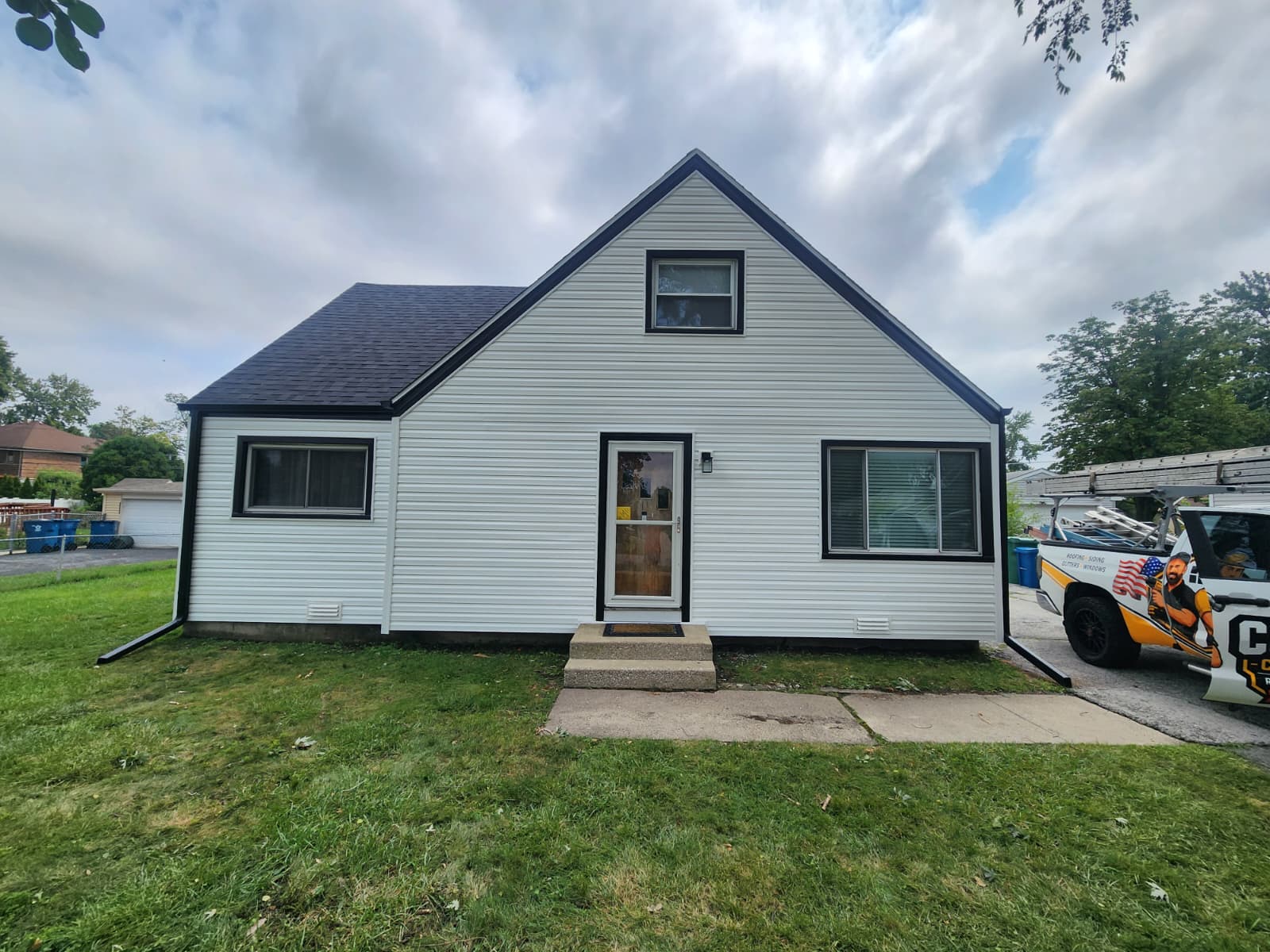 After: crisp white vinyl siding with black aluminum trim and seamless black gutters