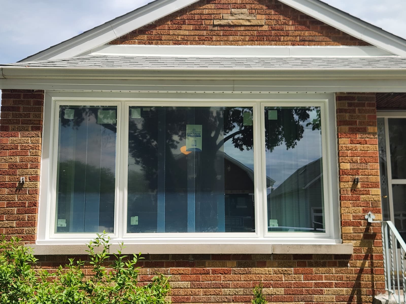 Exterior view of new picture window with white aluminum coil wrap