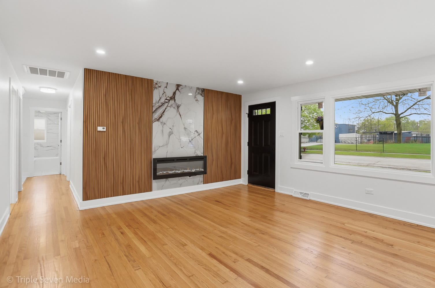 Finished living room with slat-wood feature wall and refinished hardwood floors